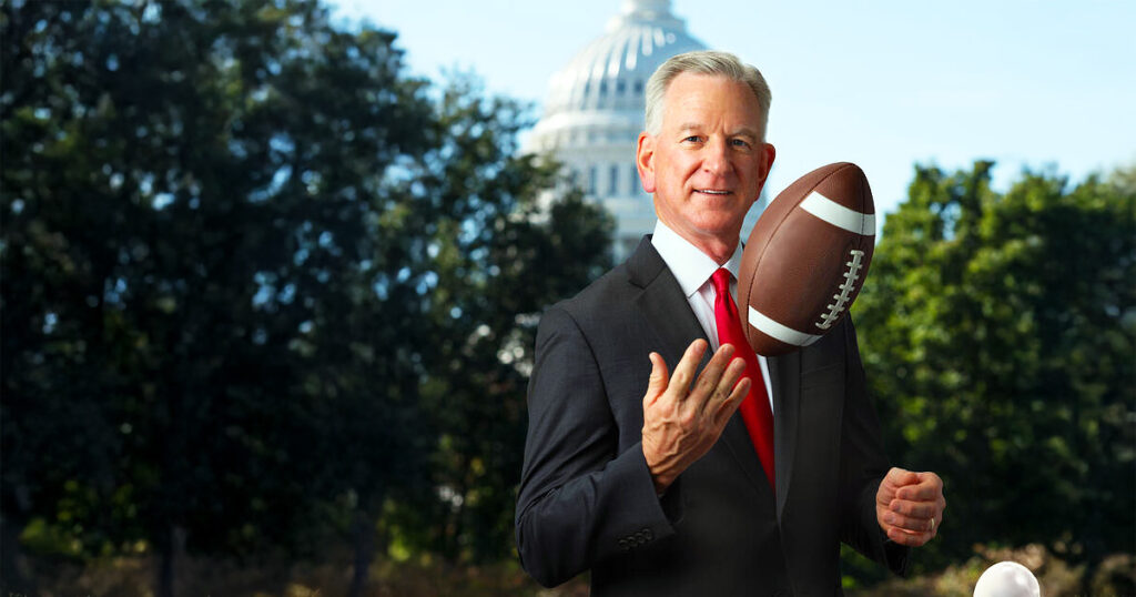 Tommy Tuberville holding a football in front of the U.S. Capitol building in Washington, D.C.